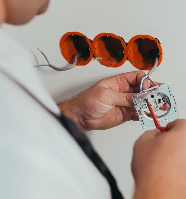 Zuverlässige Technik für Gebäude und Anlagen - Ein mann verlegt eine Steckdose