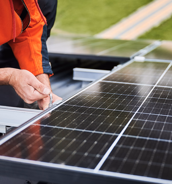 Hände montieren und verbinden Solarmodule auf einem Photovoltaikdach